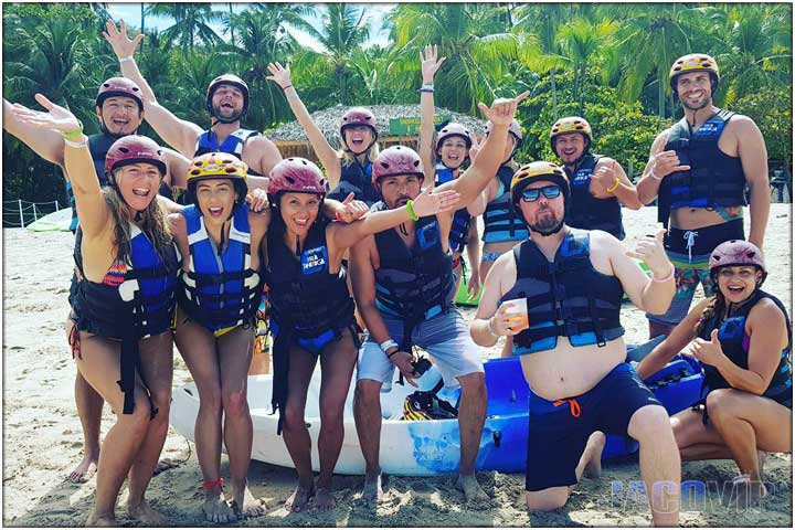 group with blue life jackets on beach