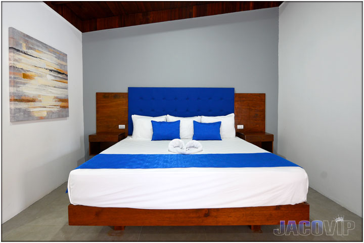 Straight on view of king size bed with white duvet and blue runner