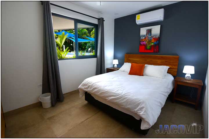 Queen size bed with red pillow and red abstract artwork above the bed