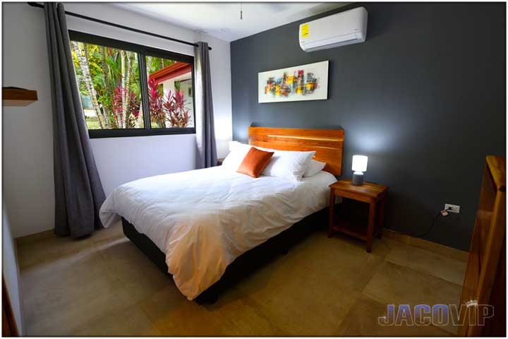 Bed with white duvet and red decorative pillow