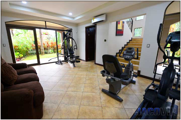 Bedroom number 10 with door open leading down staircase to resting area with sofa and tv