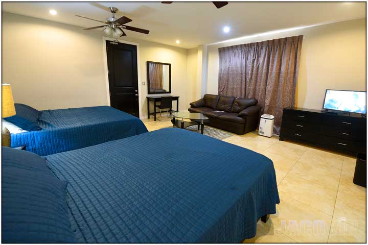 2 beds with blue covers and blue decorative pillows