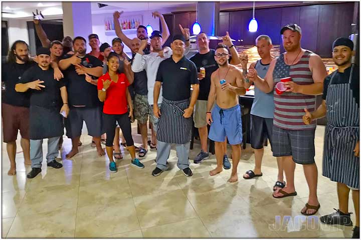 Large group of guys on vacation hanging out in the kitchen