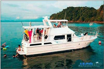 Anchored party boat with people swimming in the pacific ocean