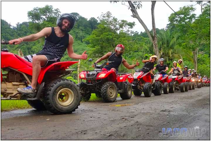 Long line of ATVs parked on side of dirt road