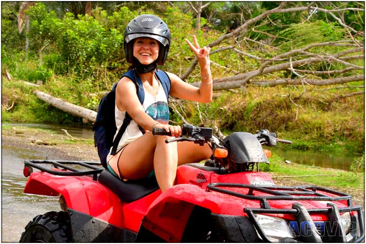 Girl making peace sign on ATV