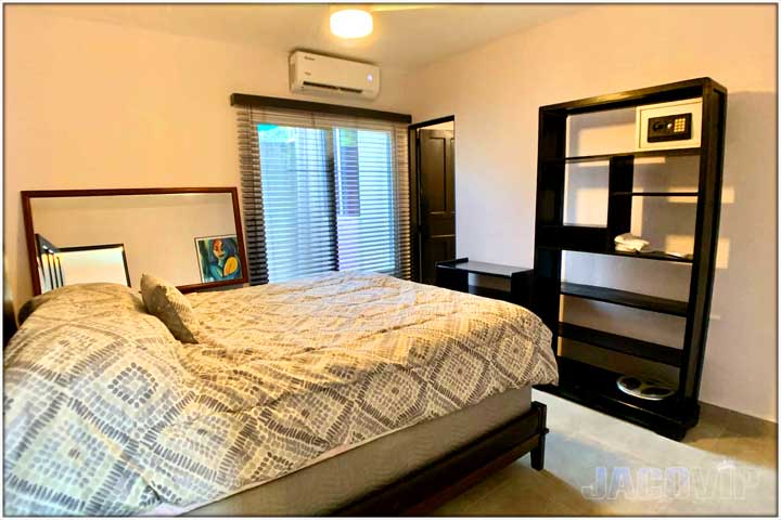 Bedroom with king bed and safe box attached to black wall unit