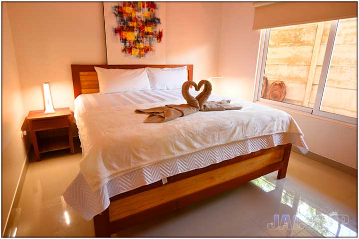 2 towels on bed in shape of kissing swans