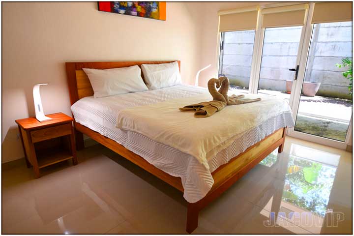 King size bed with floor to ceiling windows and doors in bedroom