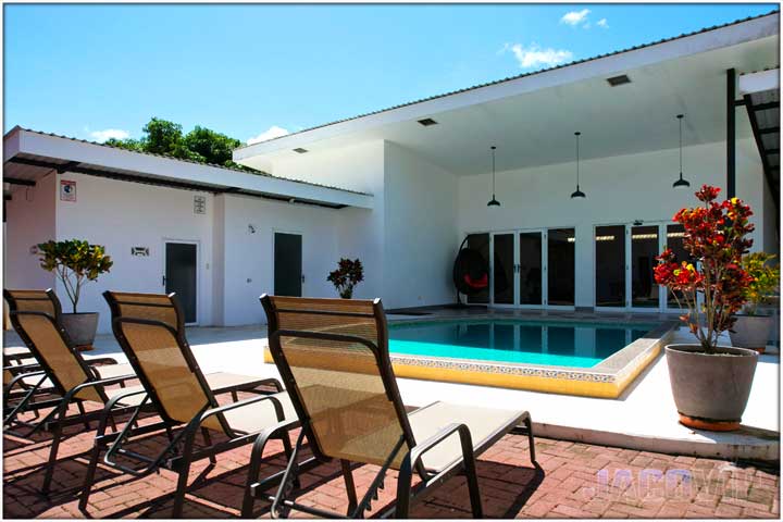 Lounge chairs facing pool and main entrance