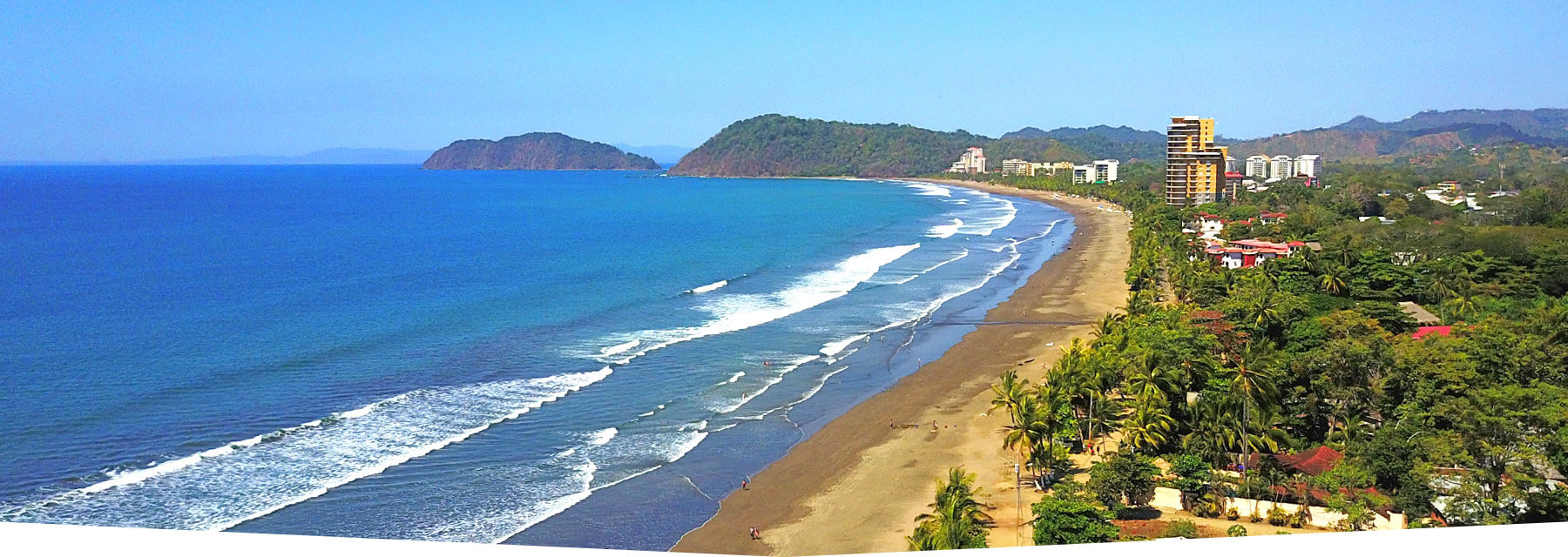 Aerial view of Jaco Beach, Costa Rica, with blue ocean and green mountains