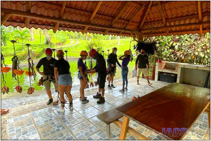 Zip Line tour guides helping tourists put on harness and helmet