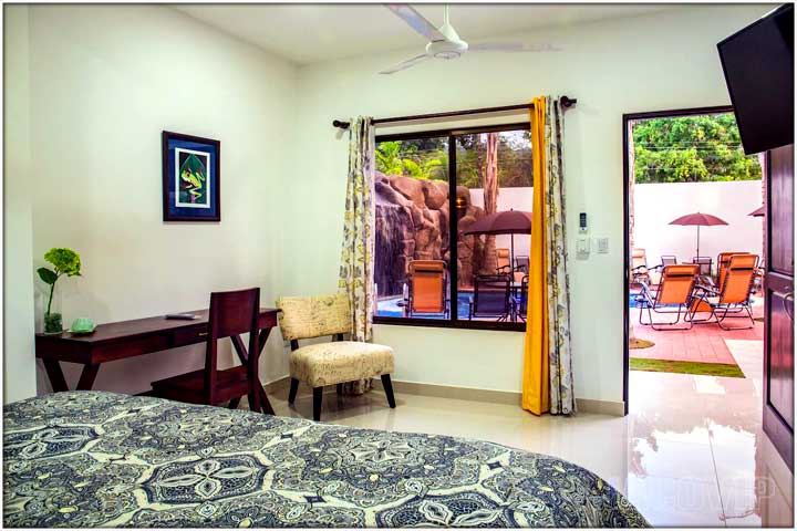 bedroom with open door leading to pool area