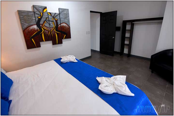 Two decorative white towels on edge of bed