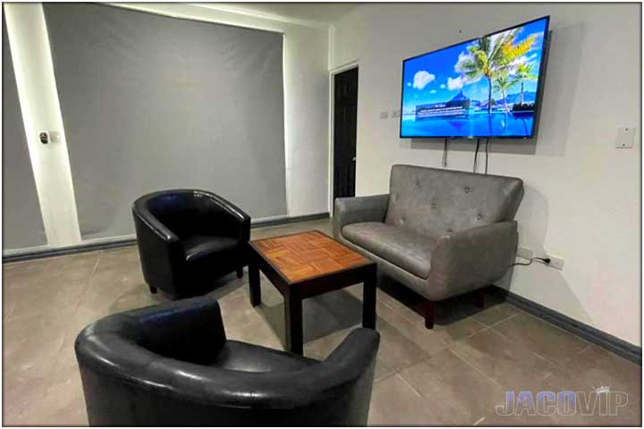 Grey sofa and two black chairs in bedroom area