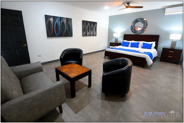 Grey sofa and two black chairs in bedroom area