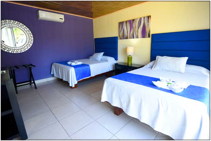 purple wall in bedroom with silver mirror