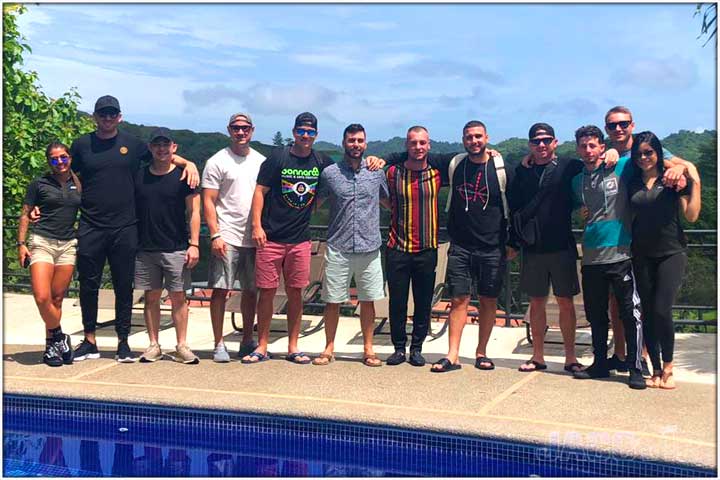 guests posing next to swimming pool