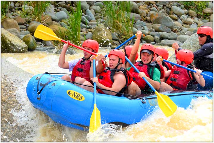 Blue raft with red life jackets and yellow paddles