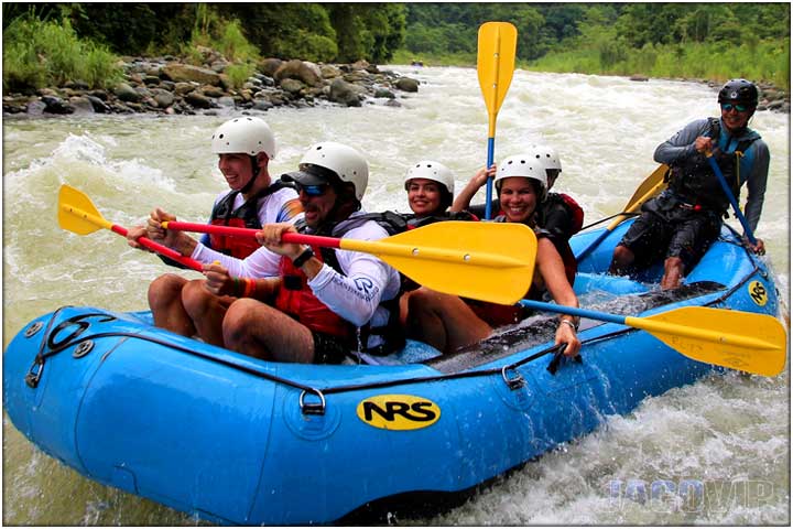 Side view of guide with group on river